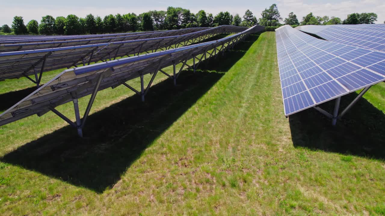 太阳能电池板农场鸟瞰图。现场用太阳能电池进行绿色能源发电。对自然环境无害的现代创新电力农场的俯视图。视频下载