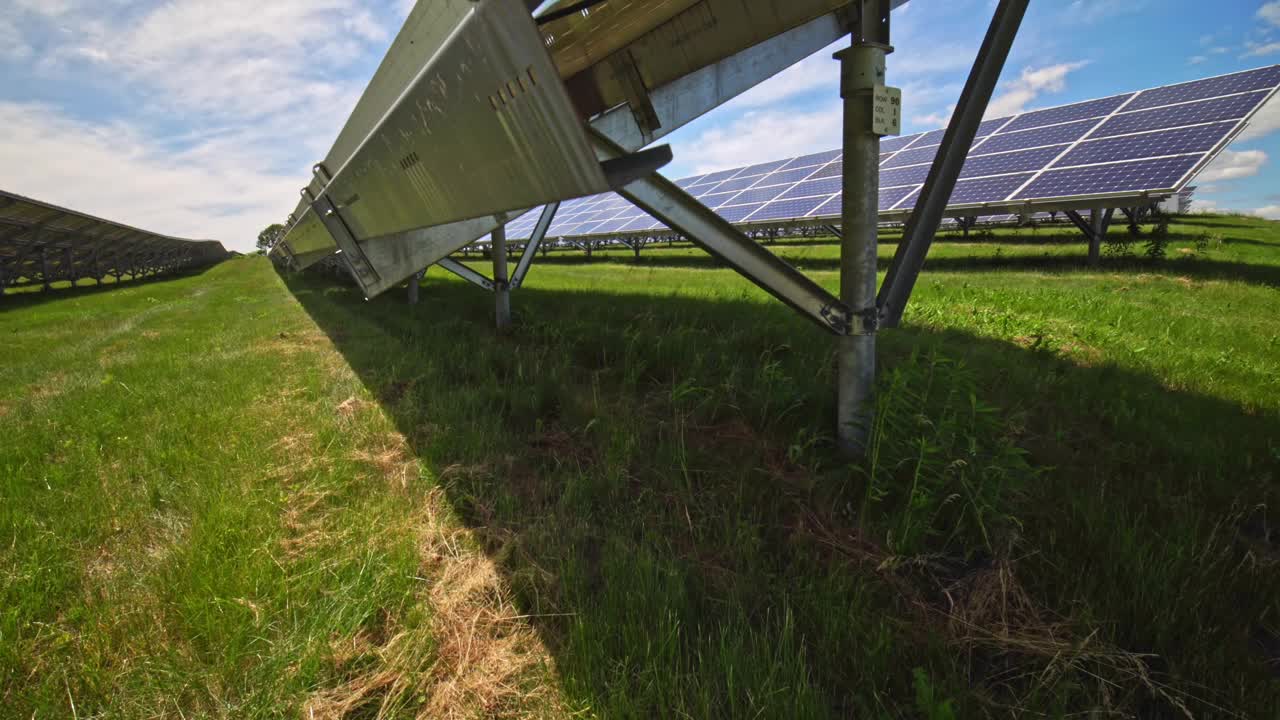 近照:现代光伏太阳能电池板为电池充电。一排排可持续能源太阳能电池板竖立在农田上。绿色能源与环境生态理念。视频下载