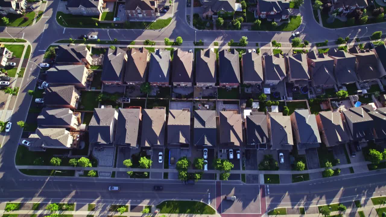 夏日傍晚中产阶级住宅鸟瞰图。美国社区郊区。住宅房屋与房屋建造者在强烈的格局中相互呼应。房地产。视频下载