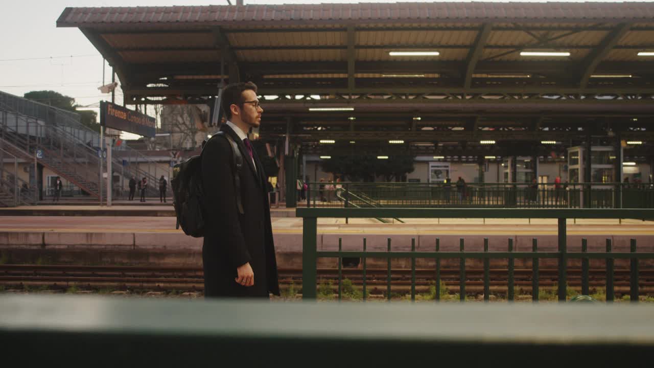 一个年轻的成年商人正走在火车站里视频下载