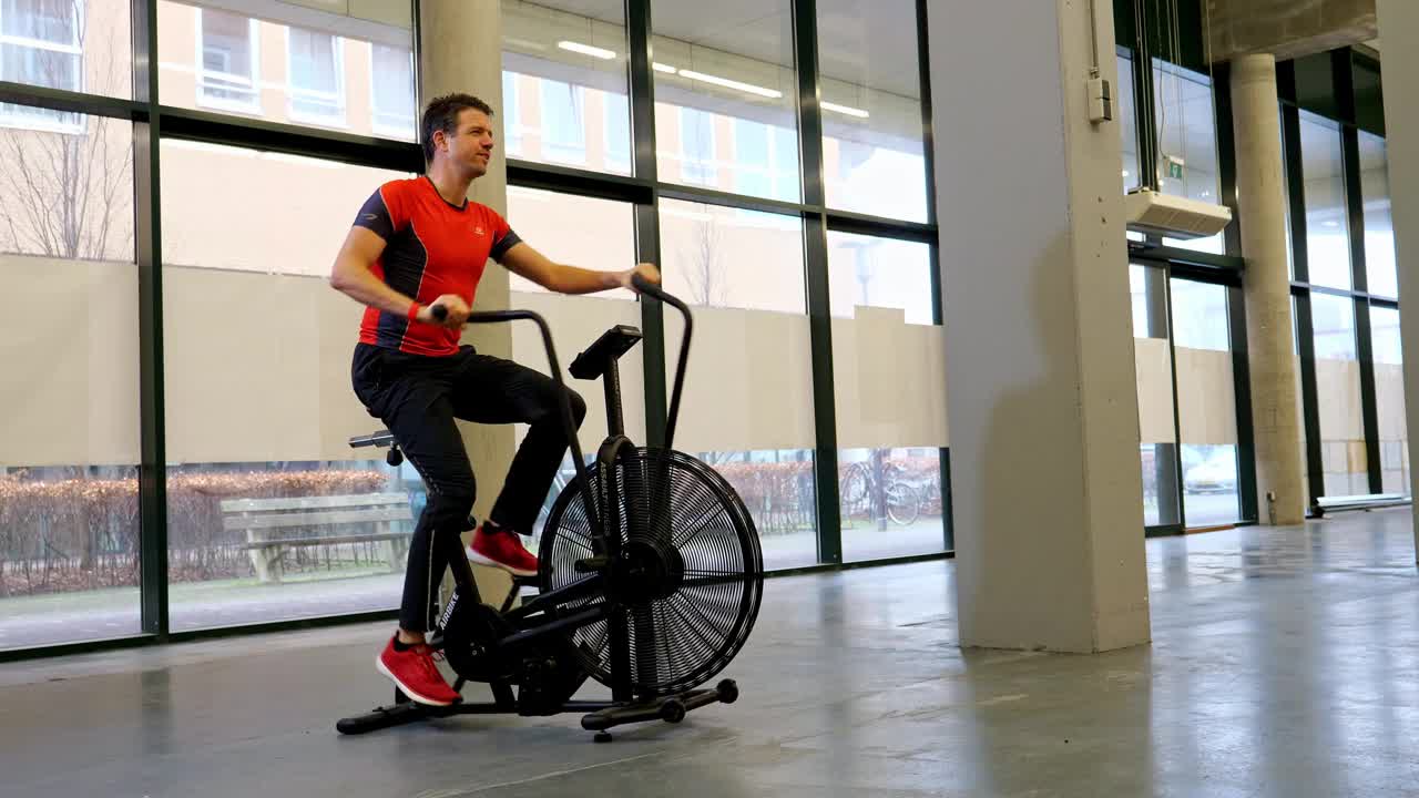 一名男子骑着空气自行车锻炼的照片。视频下载