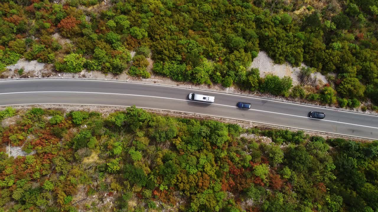 夏季，风景如画、生机勃勃的绿色植被之间的柏油路上行驶的汽车的鸟瞰图。黑山莫拉卡河的岩石峡谷。旅游目的地。无人机升起视频下载