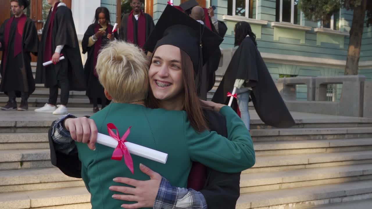收到毕业证书后，女儿微笑着拥抱母亲视频素材
