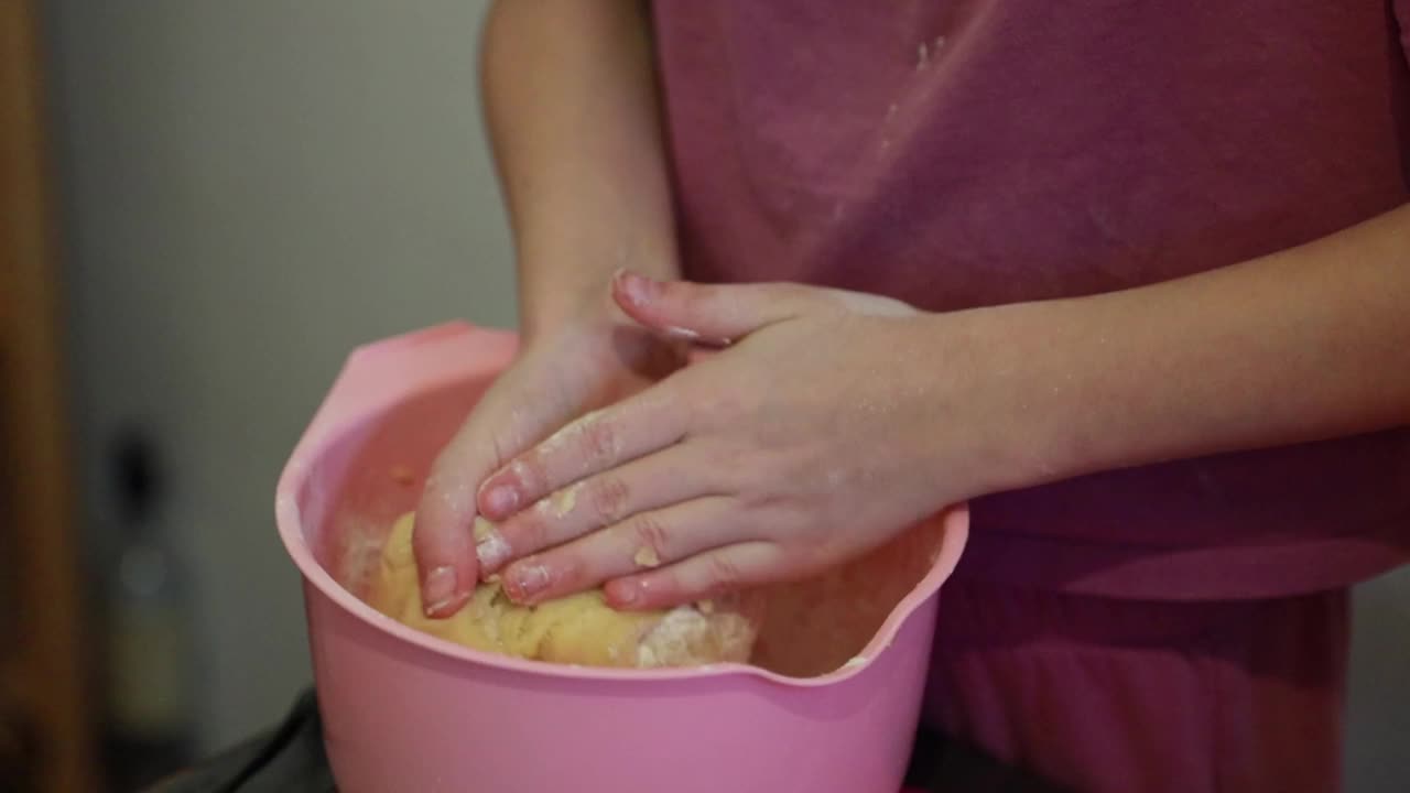 女孩用手在碗里揉面。视频下载