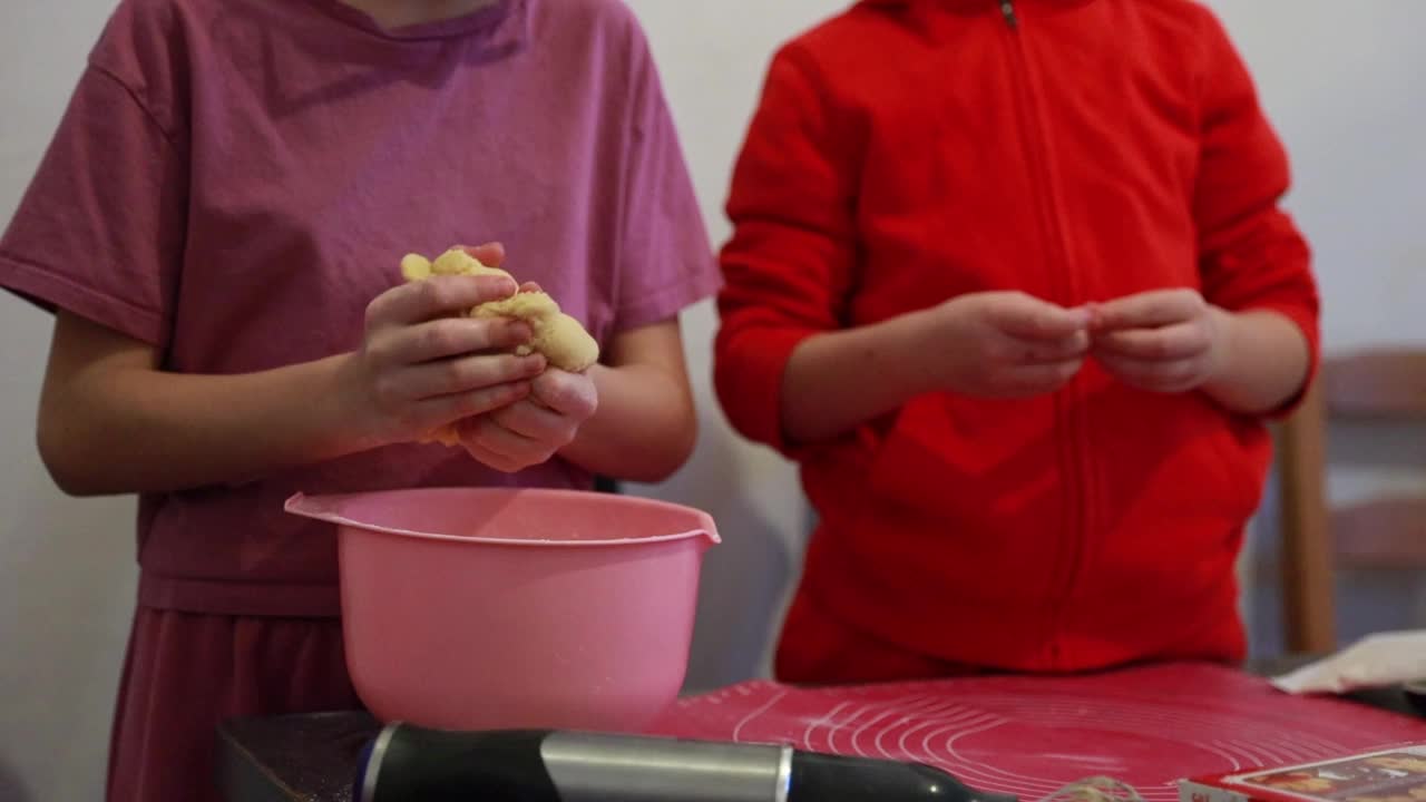 女孩们用手在碗里揉面。视频下载