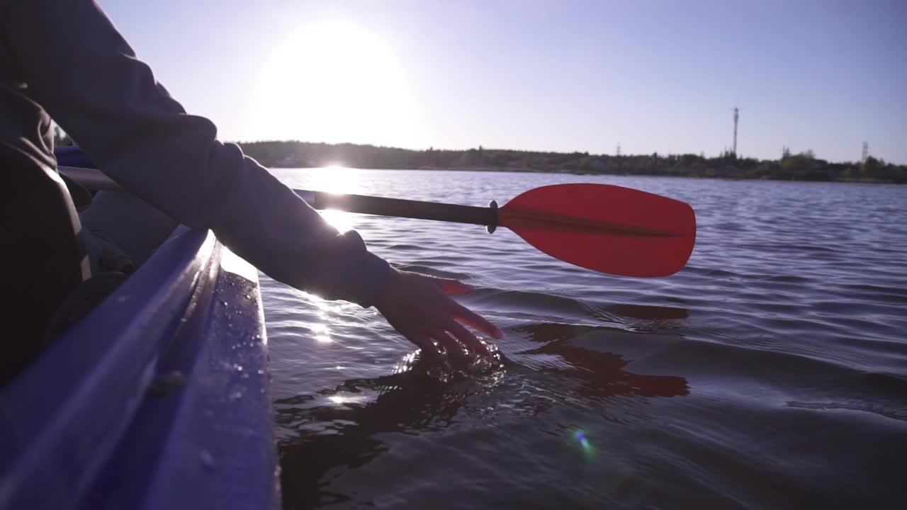 在金色夕阳的映衬下，女子在湖中泛舟，和谐自然视频下载