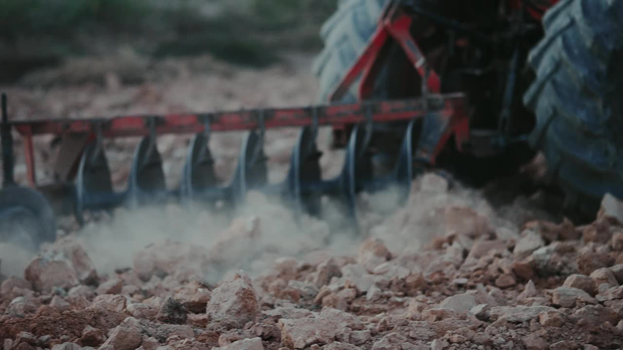 亚洲农民开着红色拖拉机在耕地上翻耕，翻出耕地中的泥土和作物残渣。2024年1月29日，在泰国清莱，准备种植玉米视频下载