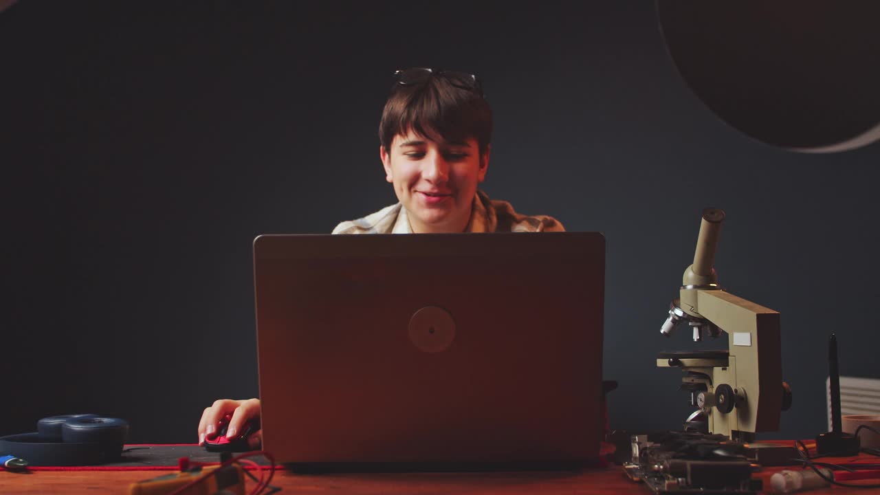 可爱的少年在他的房间里玩笔记本电脑，通过互联网交流。爱好和娱乐。无忧无虑的消遣视频下载
