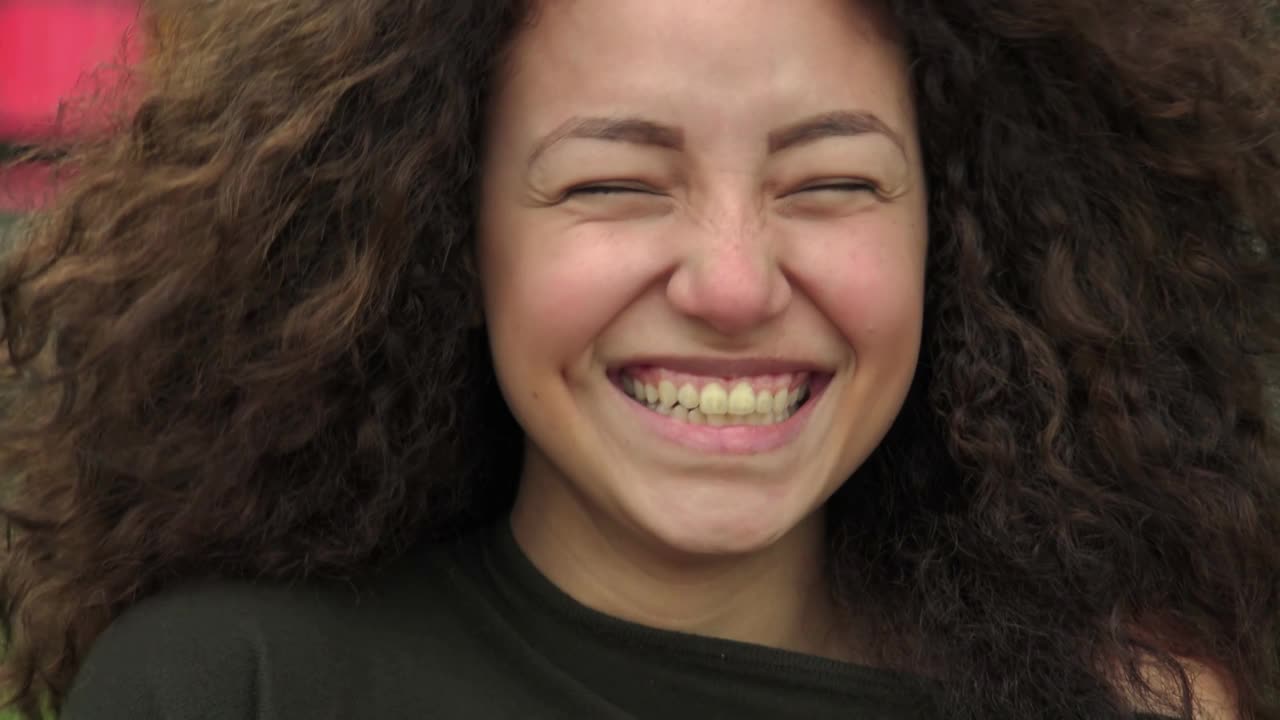 年轻的西班牙卷发女子在镜头前笑得很开心视频下载