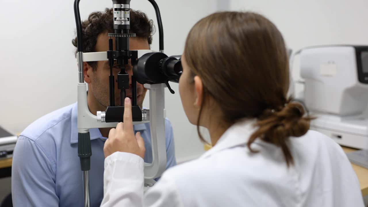 年轻的眼科学生在教学医院给病人做眼科检查视频下载