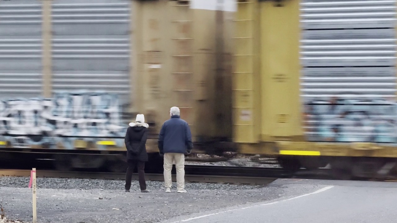 一对老夫妇看着一列货运列车驶过视频下载