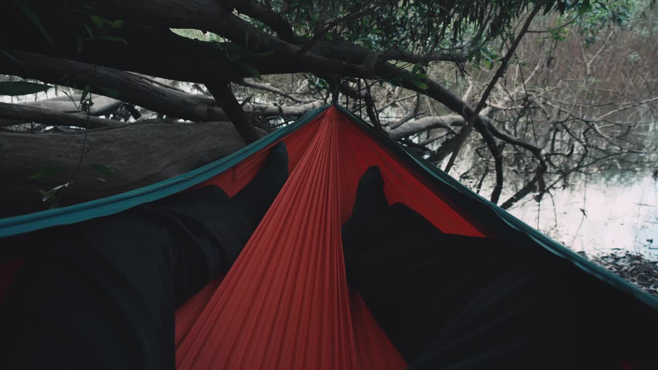 一个人在露营的吊床上享受。视频下载