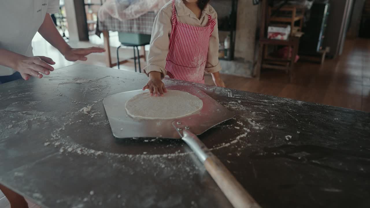 家庭在厨房的乐趣积极的情绪亚洲父亲的教学和创造的记忆，而准备披萨的小女儿周末活动视频下载