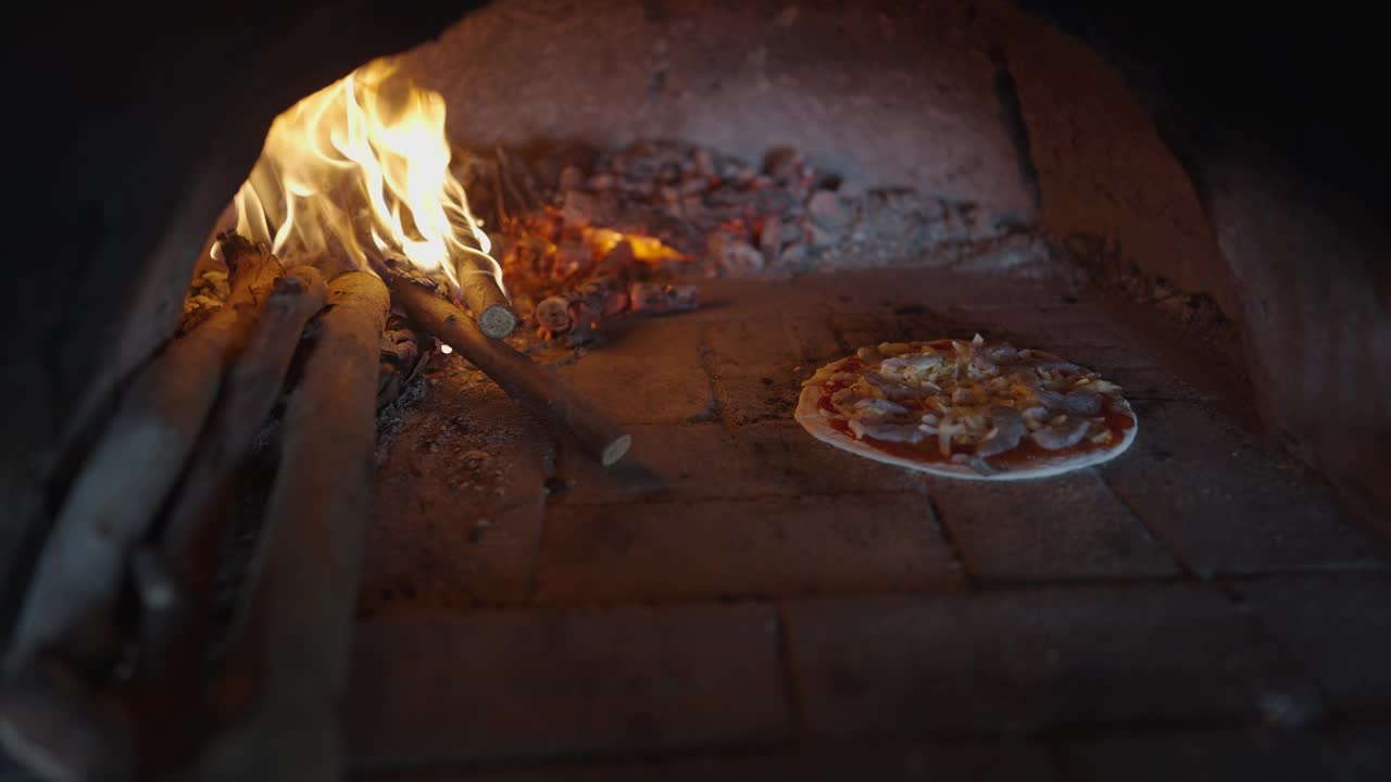 滑动镜头制作美味的手工披萨在木头燃烧的烤箱视频下载