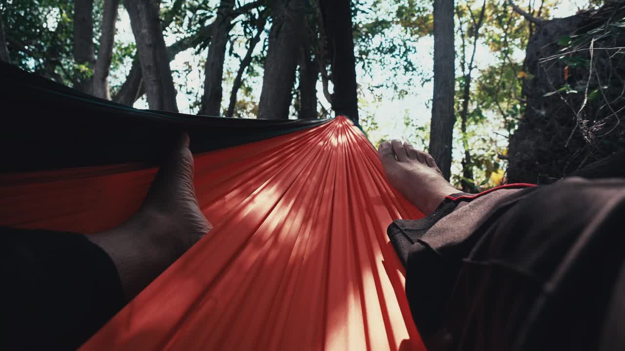 一个人在露营的吊床上享受。视频下载