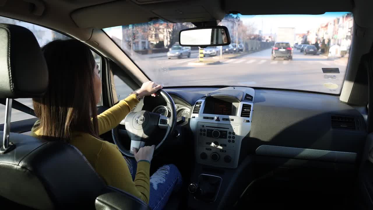 漂亮的年轻女子在城市里开车视频下载