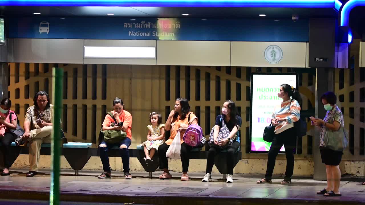 在泰国曼谷CBD地区，通勤者在公交车站等车视频下载