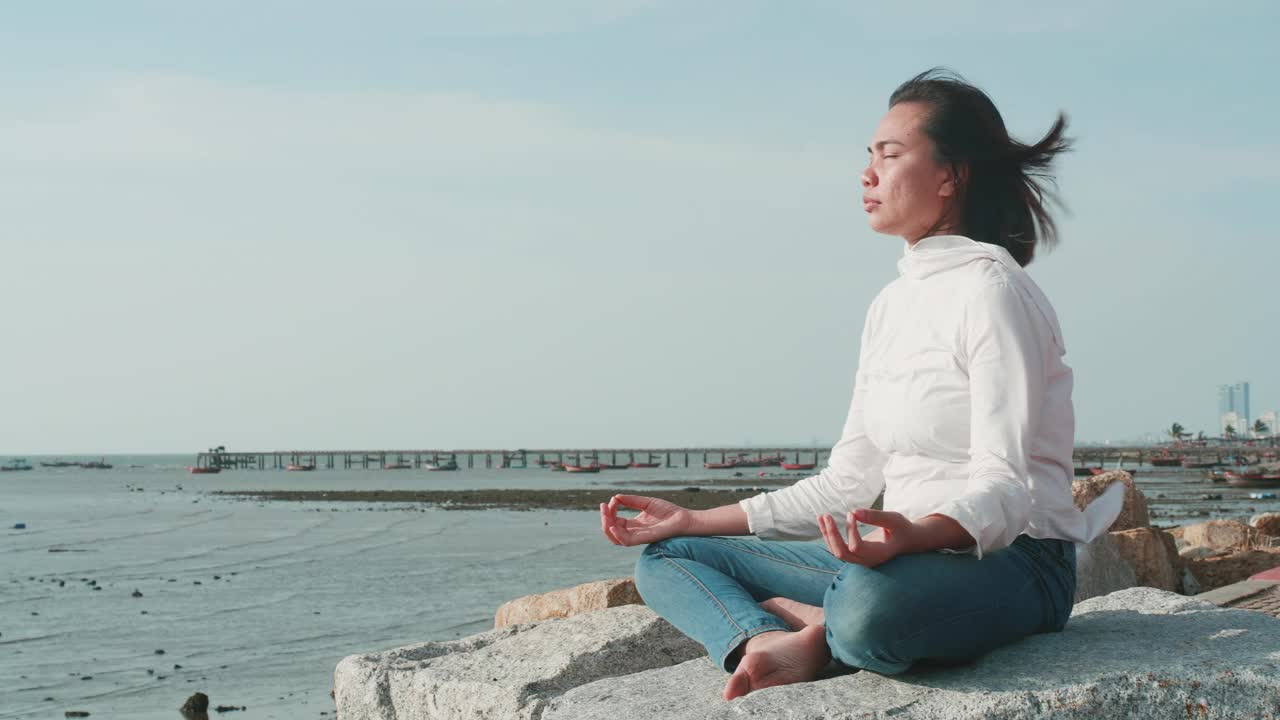 在海滩上练习或做瑜伽的亚洲女性。视频下载