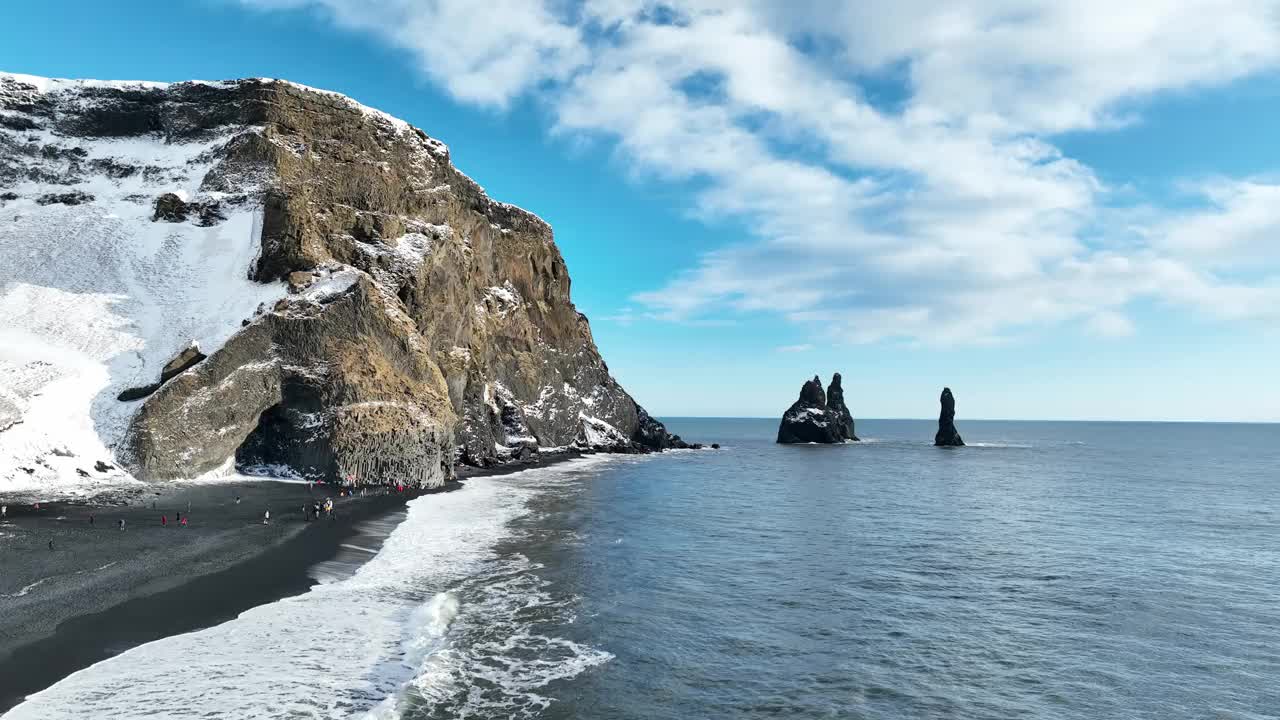 鸟瞰冰岛黑色火山海滩和海中的巨怪岩石。视频下载