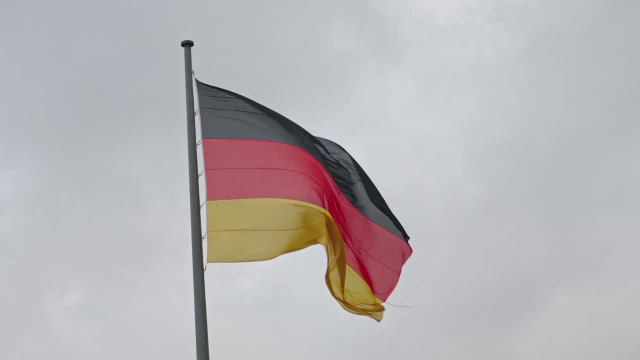 德国国旗在多云的天空中飘扬视频下载