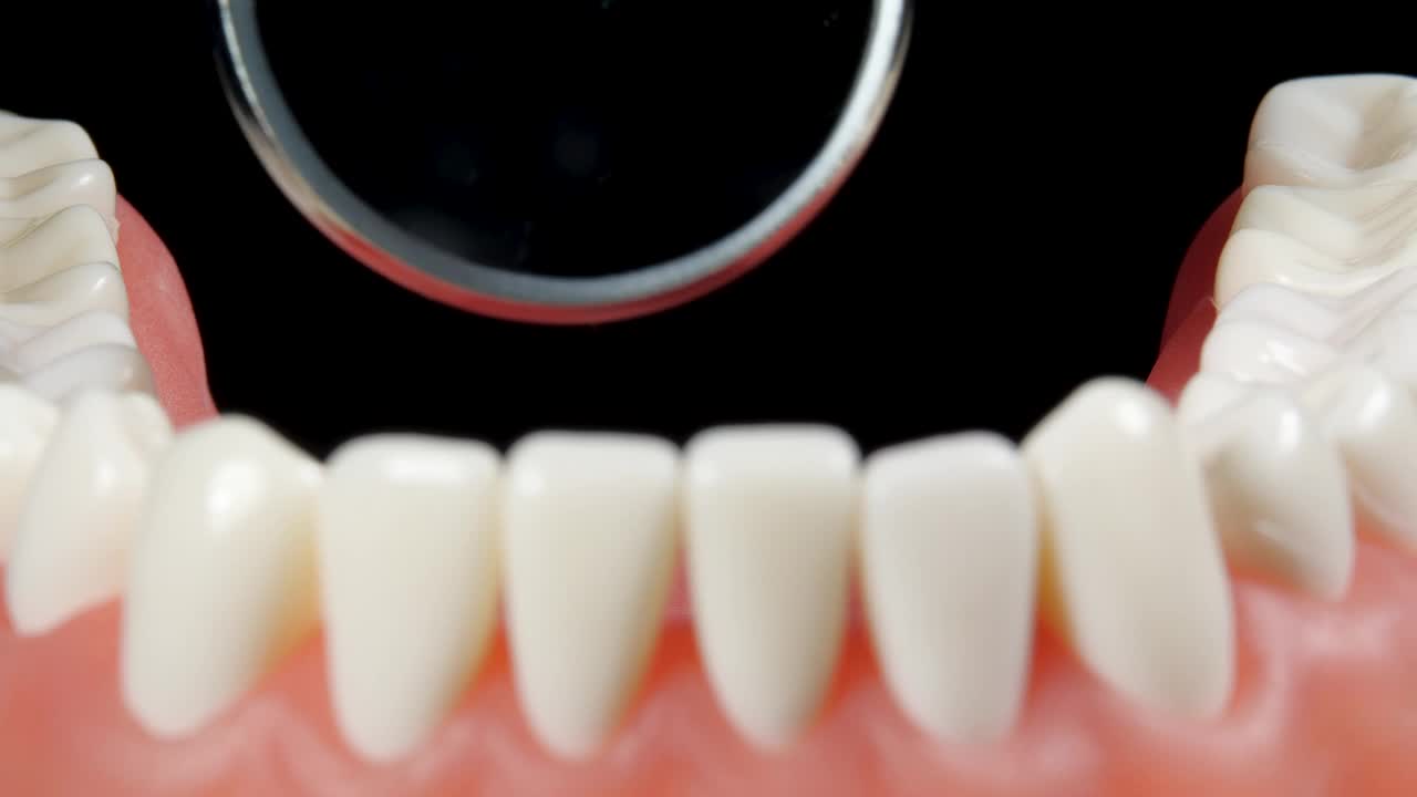 在牙科诊所预约牙医的病人。从牙颌内部观察。牙齿模型与治疗设备背景牙镜。牙齿护理和健康牙齿检查视频下载