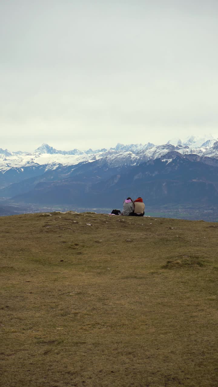 一对夫妇坐在地上看着法国阿尔卑斯山。法国。垂直视频视频下载