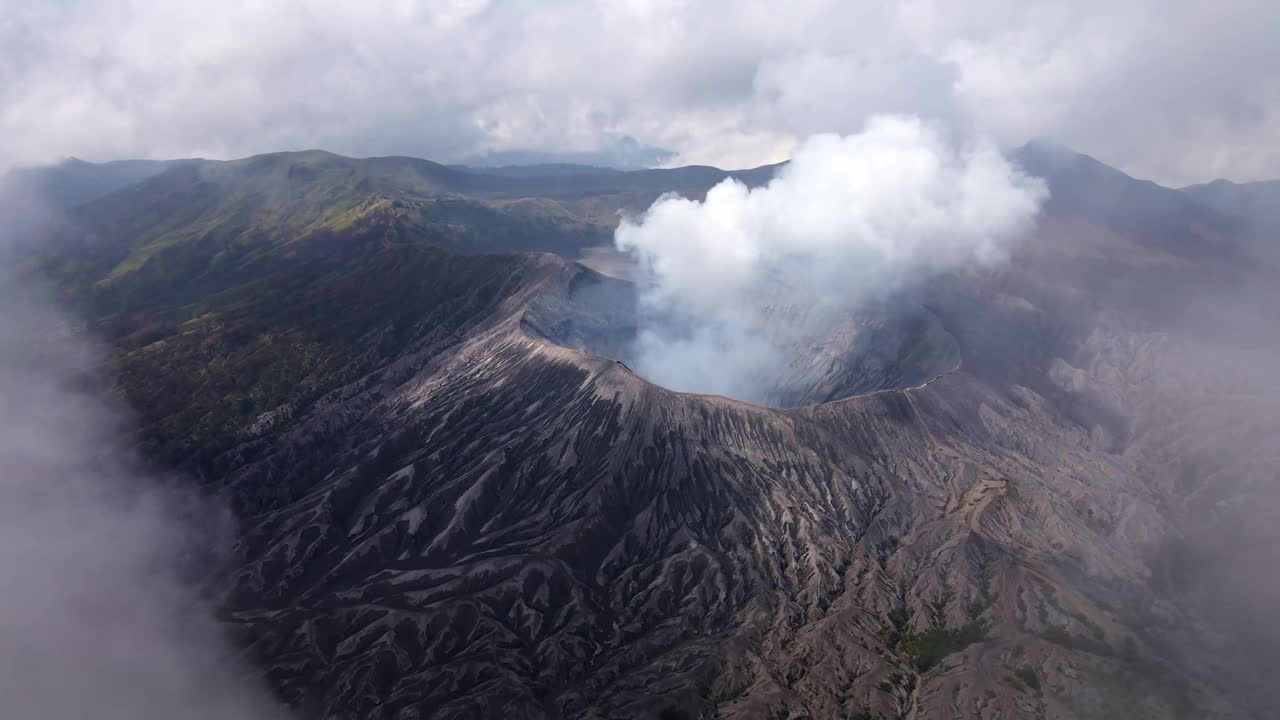 在云层之上翱翔，揭开了令人惊叹的火山活动，滚滚的烟雾和火热的喷发创造了一个令人惊叹的场景，空中4k无人机镜头视频下载