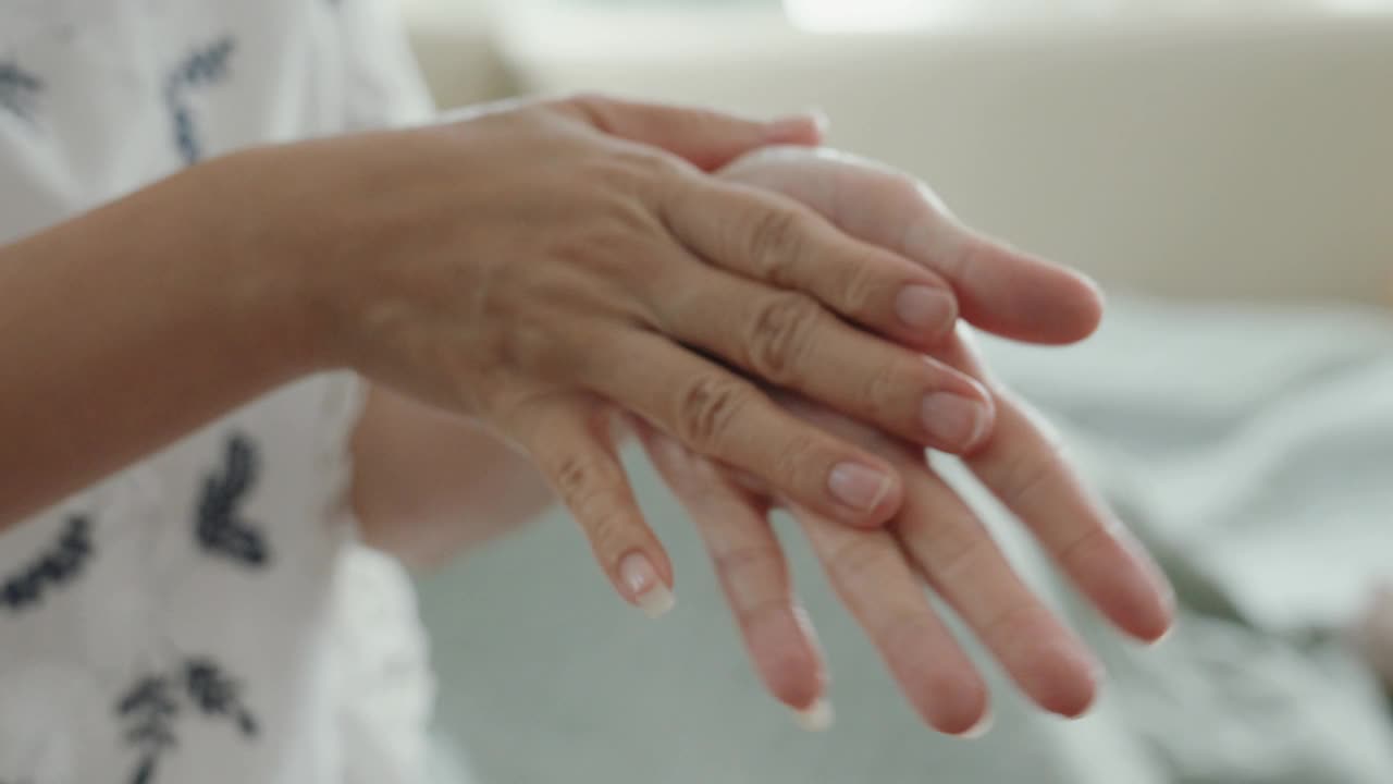 滋养护肤:亚洲女性用面霜滋润双手。视频下载