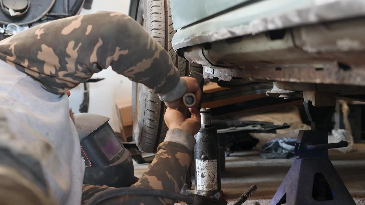机械师在修理汽车时使用锤子。视频下载