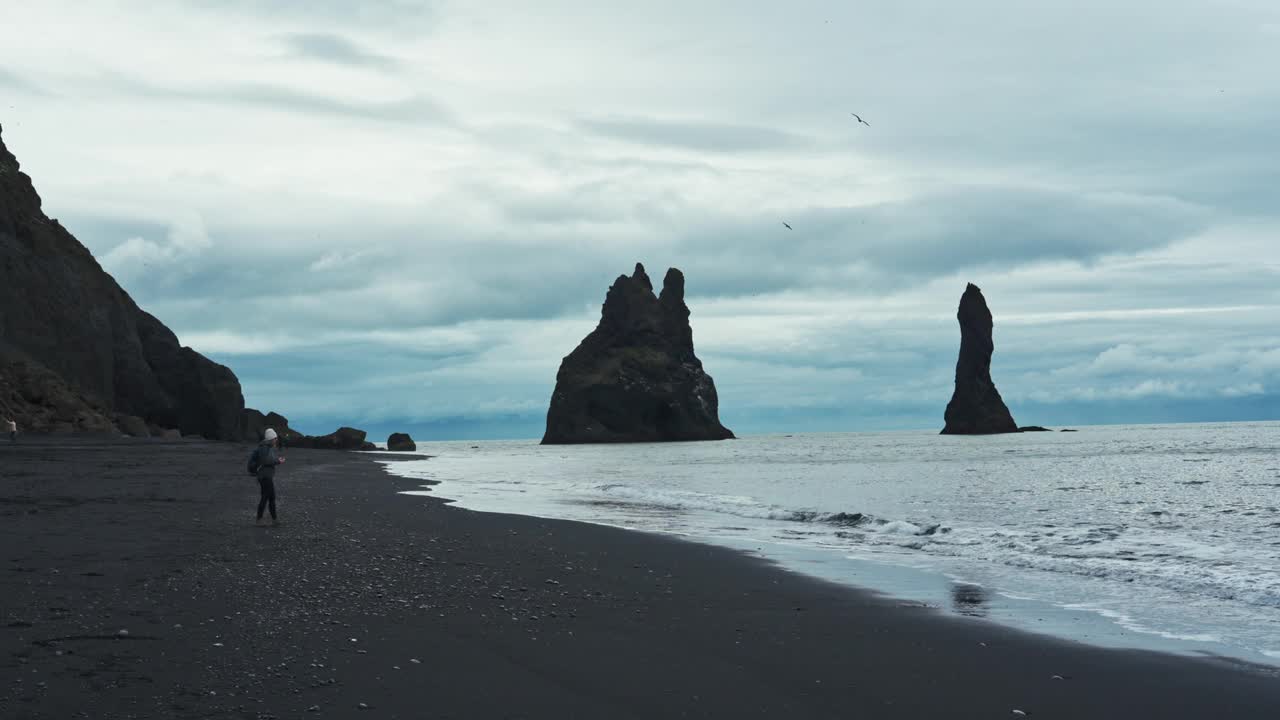 Moody Reynisdragar在冰岛维克大西洋的Reynisfjara黑沙滩上与天然岩石形成视频下载