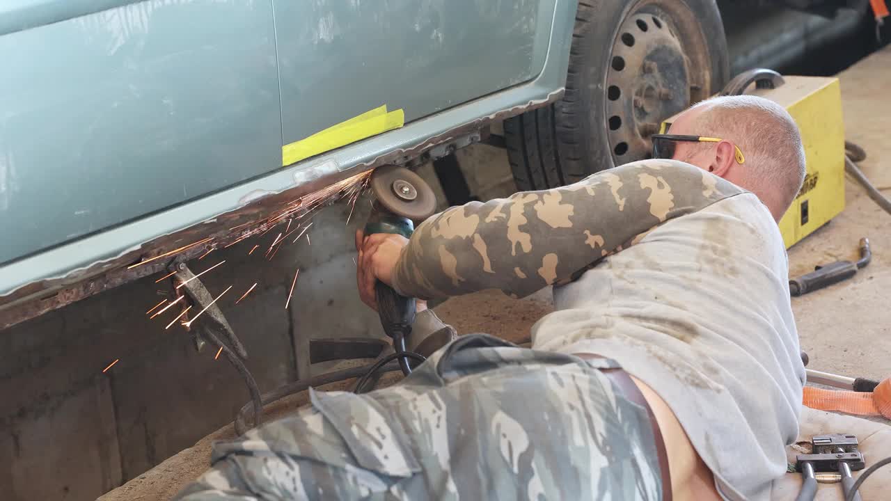 机械师用磨床除去汽车上的锈。视频下载