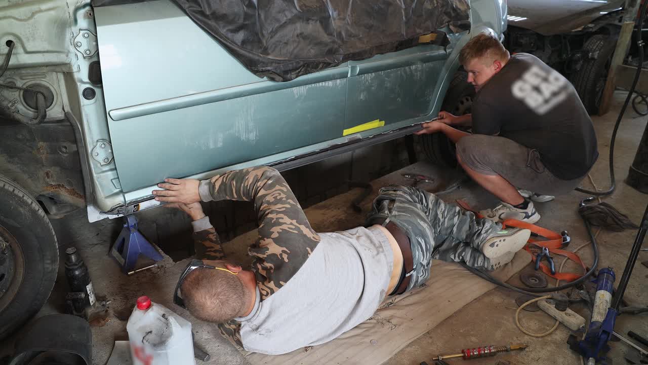 两个机械师正在汽车修理店修理一辆汽车。视频下载