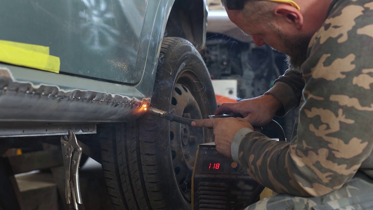 机械师把一个新门板焊接到汽车上。视频下载