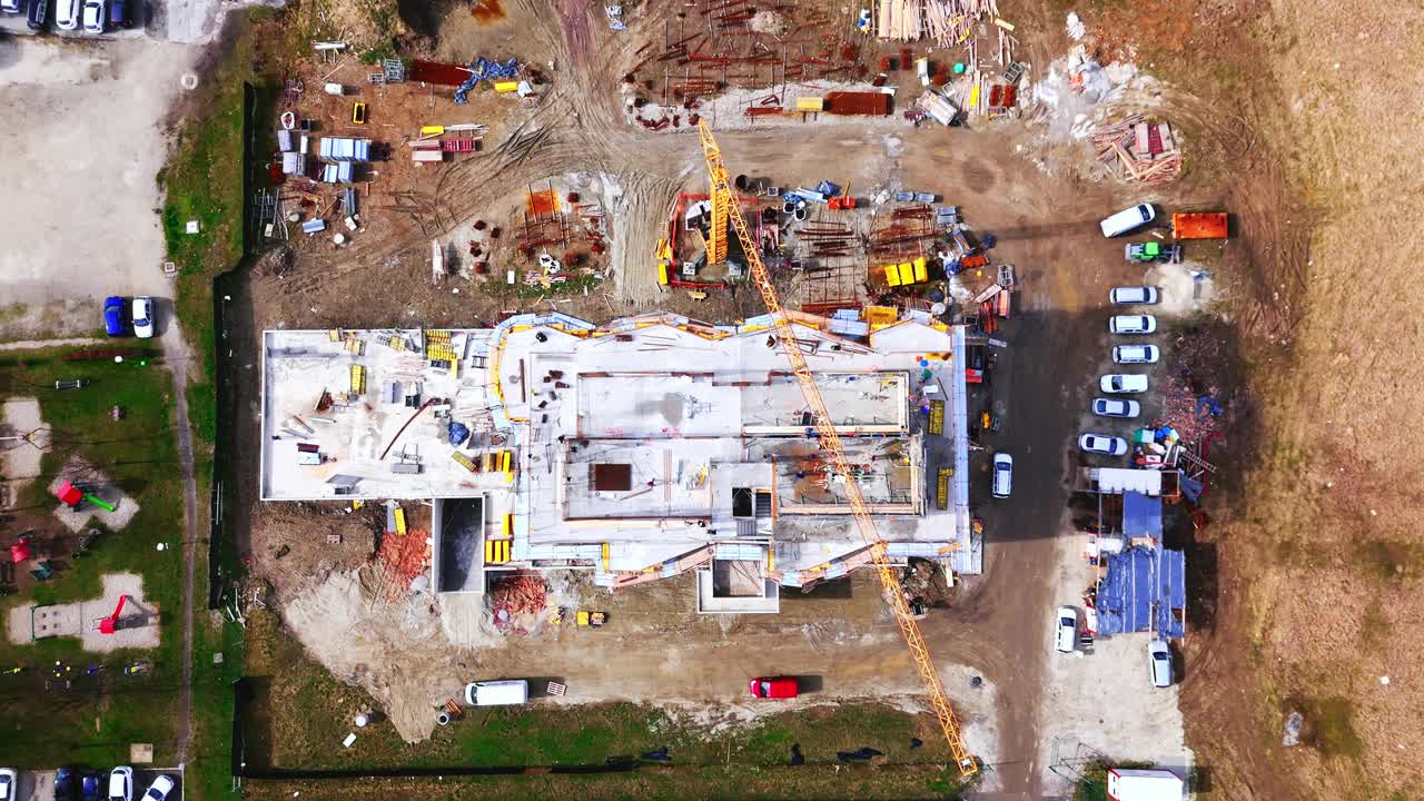 无人机拍摄的工人在建筑工地未完工建筑的露台上工作视频素材