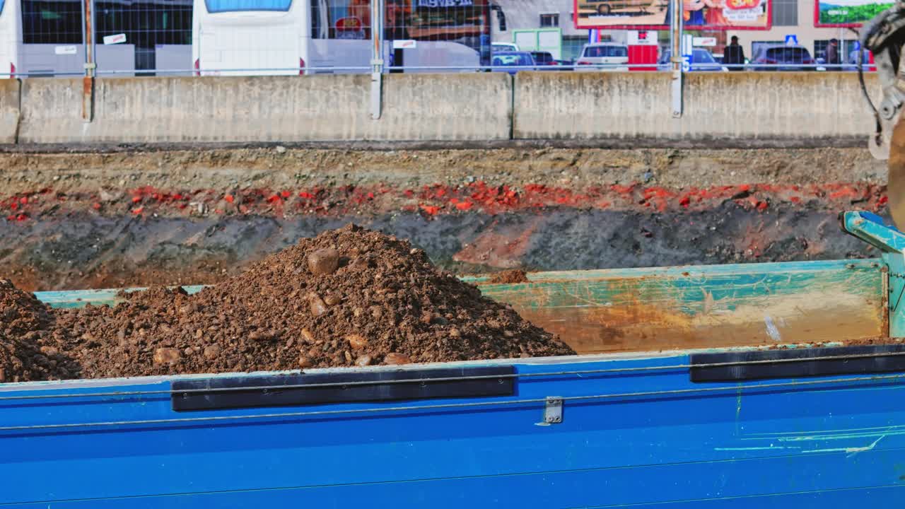 建筑工地上挖土机装载自卸车沙子的特写镜头视频素材