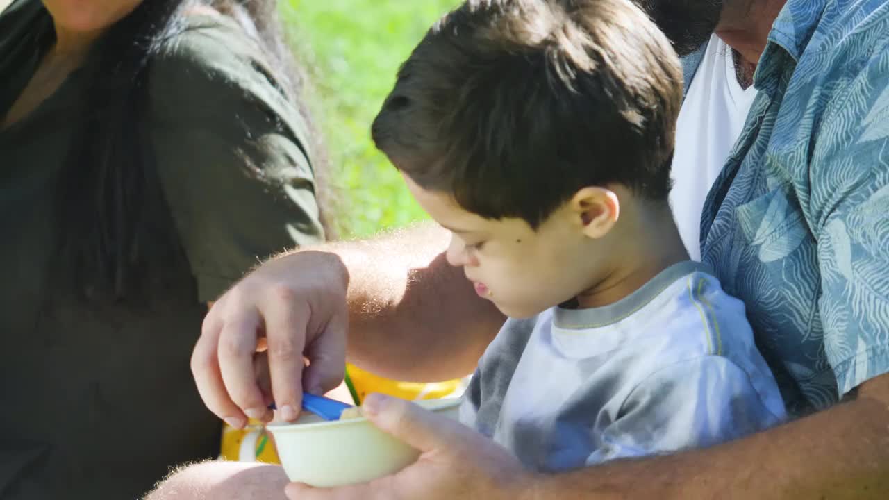 父亲帮助患有唐氏综合症的儿子在后院吃东西视频下载