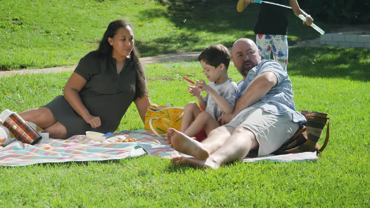 父母带着孩子在阳光明媚的日子里野餐视频下载