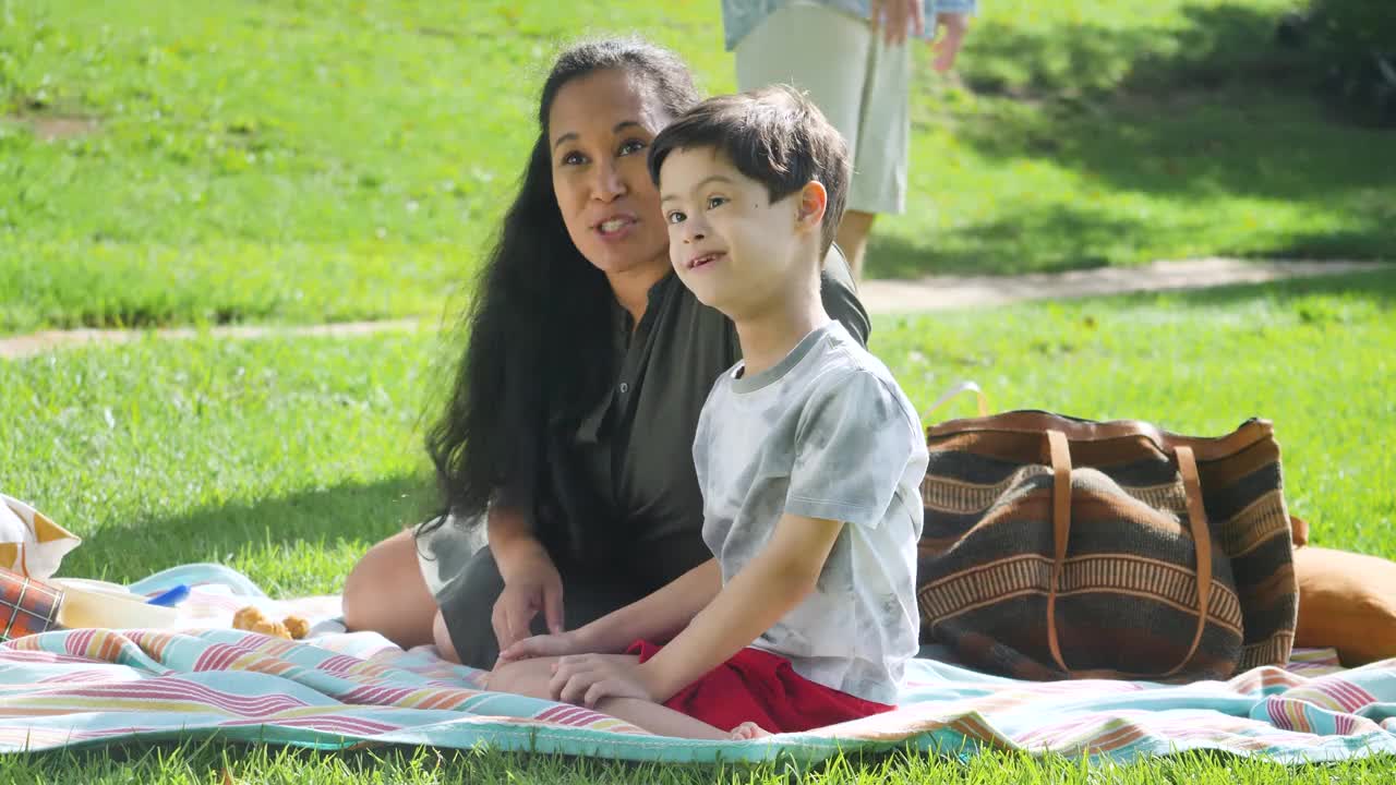 阳光明媚的一天，母亲带着患有唐氏综合症的儿子在后院玩耍视频下载