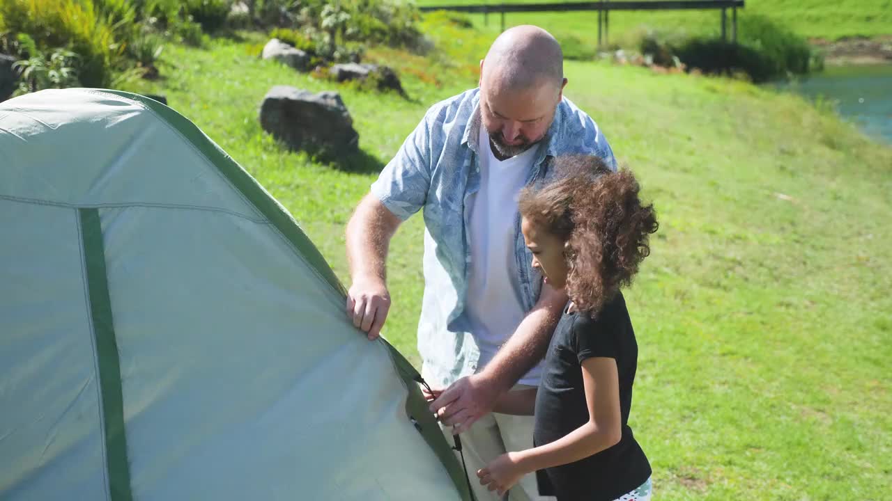 父亲和女儿在风景中搭帐篷视频下载