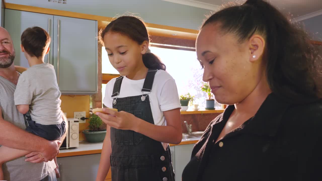 父母带着两个孩子在厨房里吃煎饼视频下载