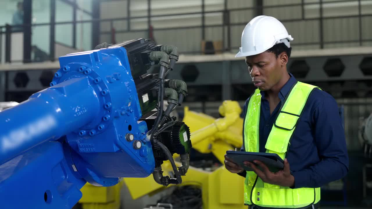 非裔美国工程师、技术员使用平板电脑检查机器人机械臂视频下载