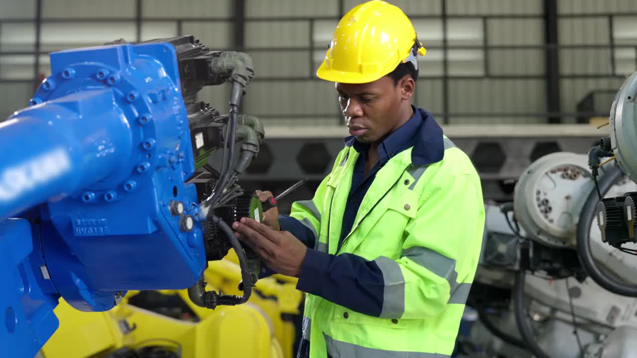非裔美国工程师、技术员在焊接工厂用螺丝刀检查机器人机械臂视频下载