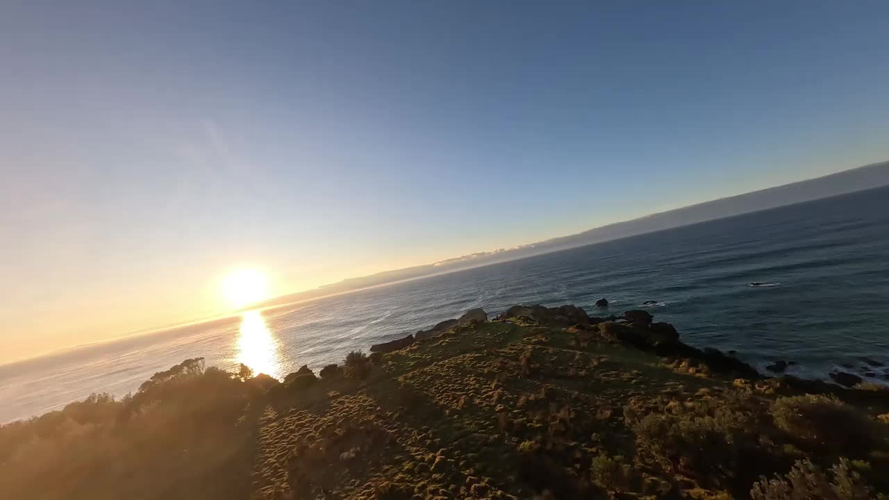 日出时两个人站在悬崖顶上的鸟瞰图。视频下载