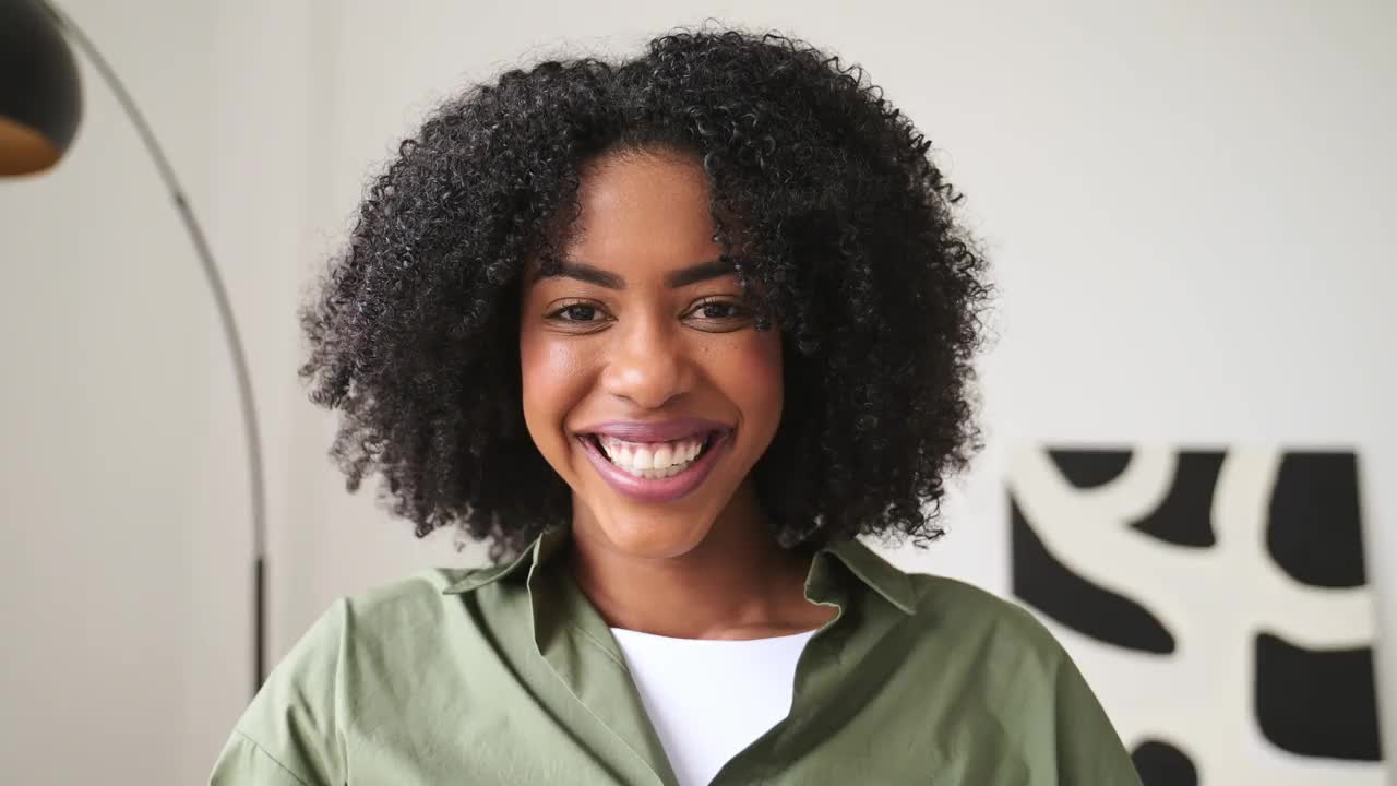 一位非洲裔美国妇女带着灿烂的微笑，在她的笔记本电脑上享受着愉快的时刻视频下载