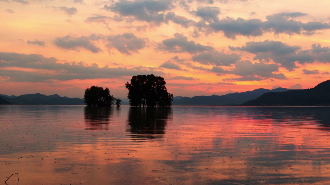 美丽的傍晚色彩在日落后的山脉，湖泊与镜子反射在水面上视频下载