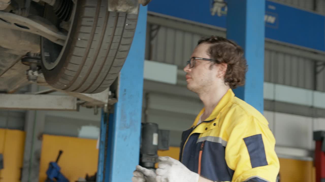 技师转动汽车的轮胎以检查轮胎的状况。视频素材