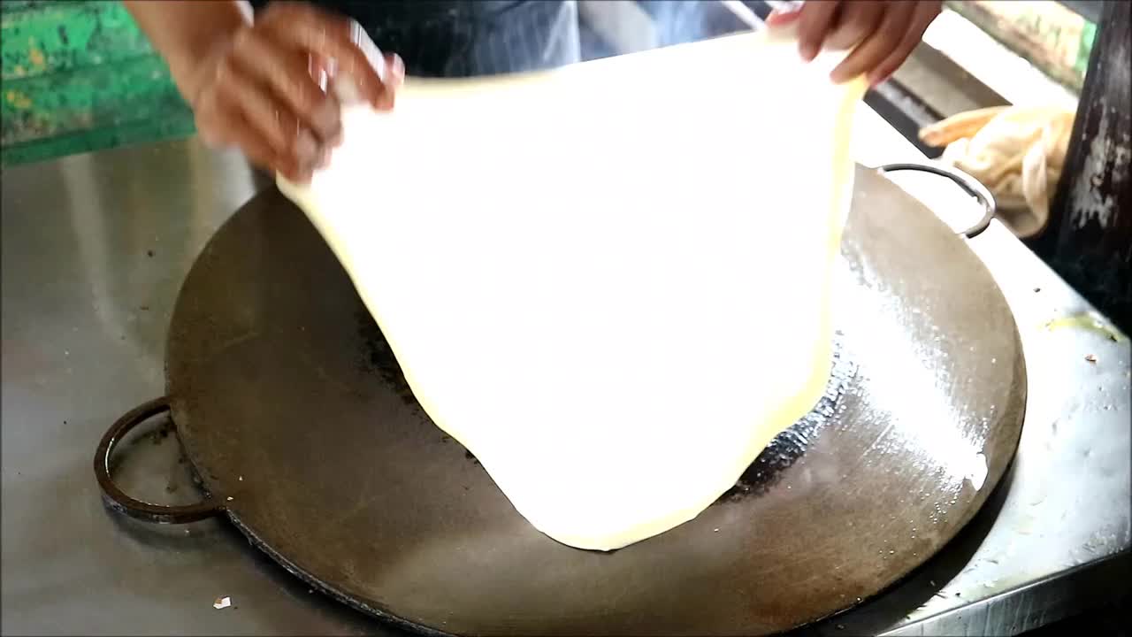 厨师在铁锅上煎烤面团的镜头视频下载