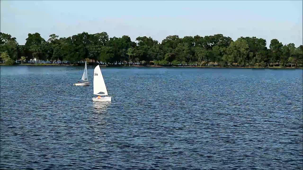 人们在湖上享受帆船和皮艇的镜头视频下载