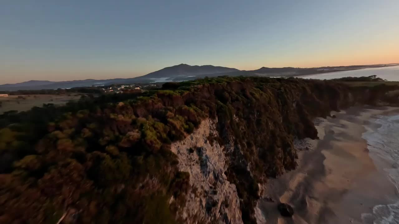 鸟瞰悬崖顶部，树木和两个观看日出的游客。视频下载