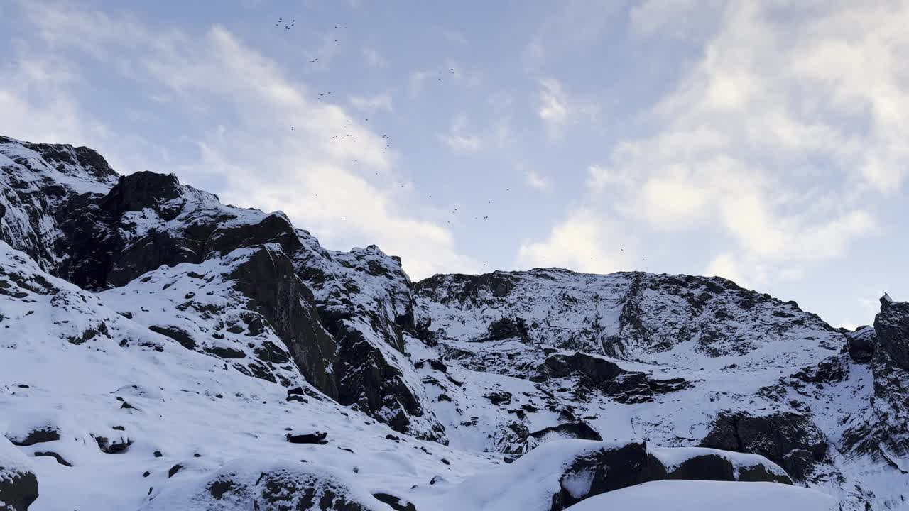 蓝蓝的天空下，白雪皑皑的山坡上有岩石和雪视频下载